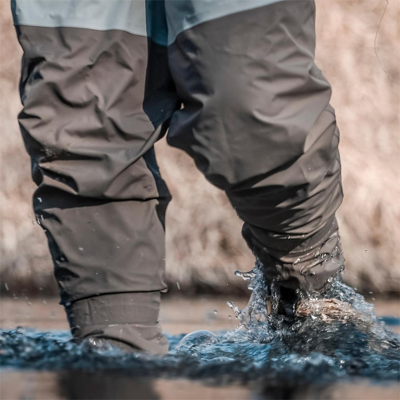 Close-up of Trudave BreezeFly Series men’s lightweight waterproof fishing chest waders – legs in water showing durable neoprene fabric and watertight seams for fishing performance